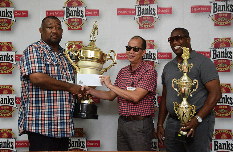 BCB President, Hilbert Foster accepts the sponsorship cheque from Banks DIH Banks Beer Brand Manager, Brian Choo Hen, in the presence of Banks DIH Special Events Manager Mortimer Stewart. (Adrian Narine photo)