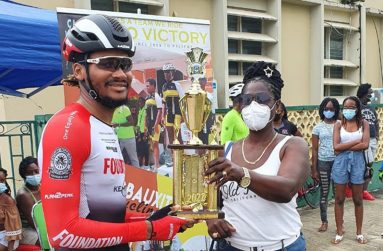 Michael Anthony at left receives the winner's trophy from Linden Town Council Councillor Ms Fern McKoy.