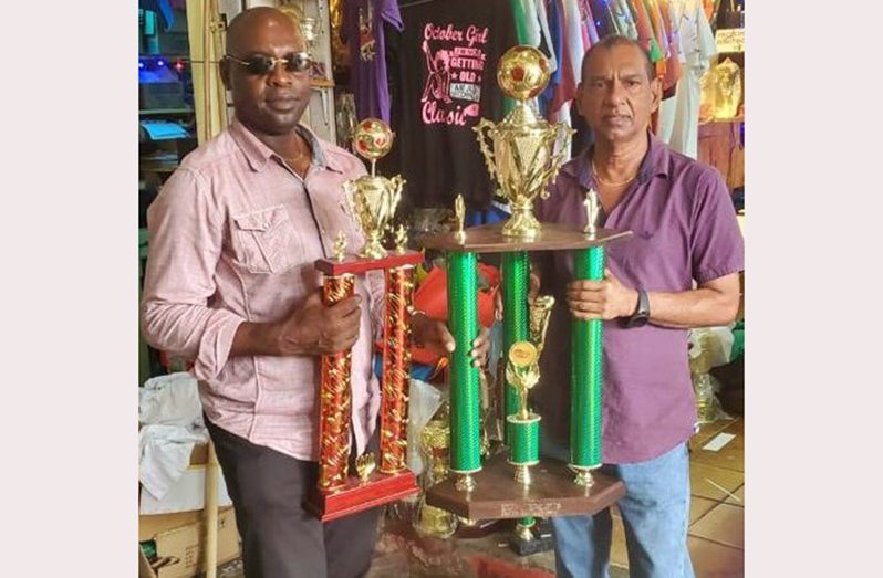 Proprietor of Trophy Stall of Bourda Market, Ramesh Sunich (right), displays the winners’ trophy alongside K&S co-director Aubrey ‘Shanghai’ Major who holds the MVP hardware.