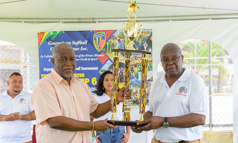 Prime Minister Mark Phillips and GSCL president Ian John pose with one of the trophies that will be up for grabs in the tournament. (Delano Williams photo)