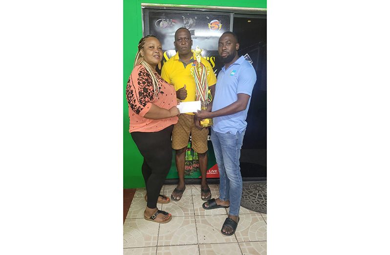 IN photo, captain of Big Boss Female Team, Charlyn Barnwell receives the third-place trophy with medals and sponsorship cheque from Mr. Mortimor Robertson, Head of Business Development VSH United (Guyana) Inc. with organiser of the tourney, Roderick Harry