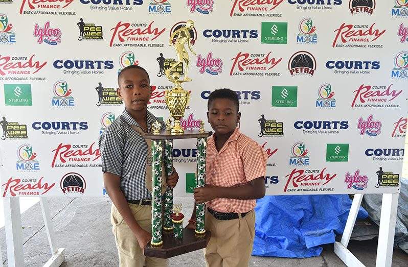 Omari Moses of St Pius Primary (left) and Fabio Kowlessar of Enterprise Primary hold the trophy they will be vying for tomorrow