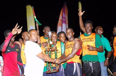 Tournament winners Tucville collect their trophy from Petra director Troy Mendonca after beating North East La Penitence 2-1 on penalties. (Delano Williams photo)
