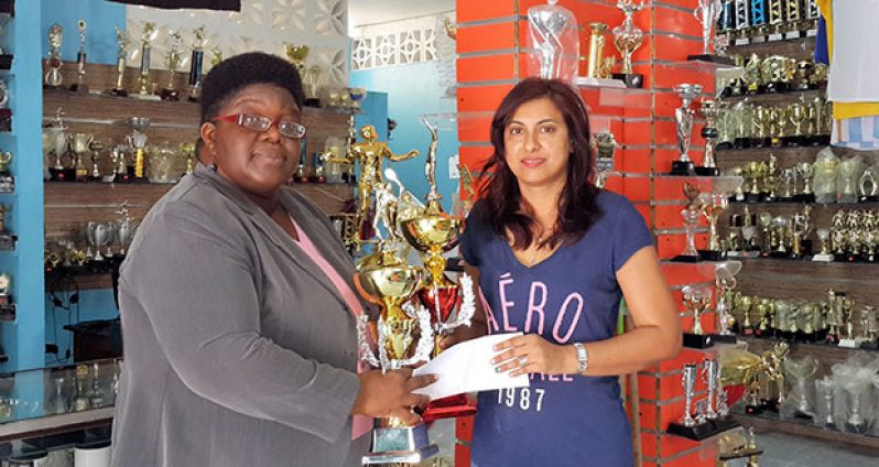 Mrs. Devi Sunich (left), wife of the proprietor of Trophy Stall Ramesh Sunich, hands over the sponsorship cheque and symbolic partner trophies to president of the GTA Grace McCalman
