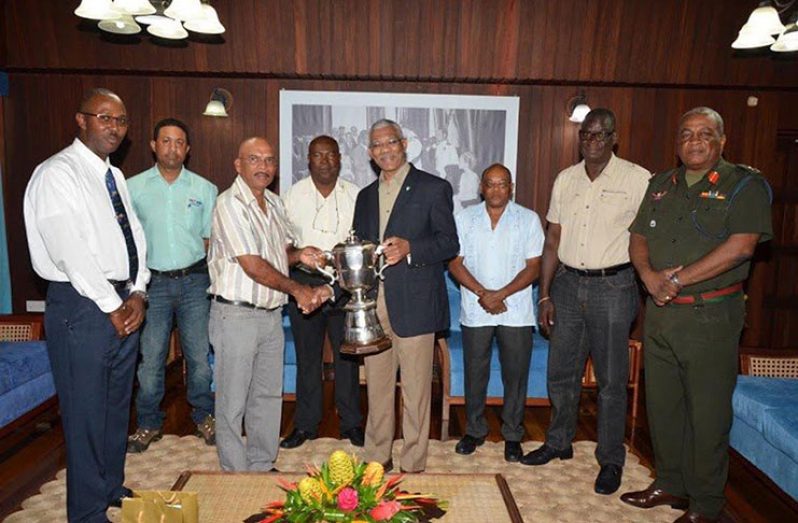 Flashback! President David Granger being presented with the championship trophy by the GNRA captain Mahendra Persaud, while members (from L-R) Ryan Sampson, Dylan Fields, Lennox Braithwaite, Terrence Stuart, Paul Slowe and then-Brigadier General Mark Phillips look on.
