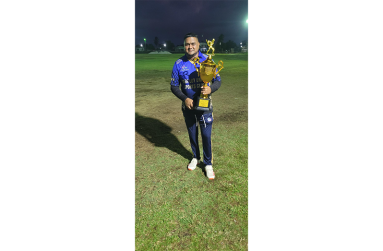 Dr Joel Dilchand poses with one of his many cricketing trophies