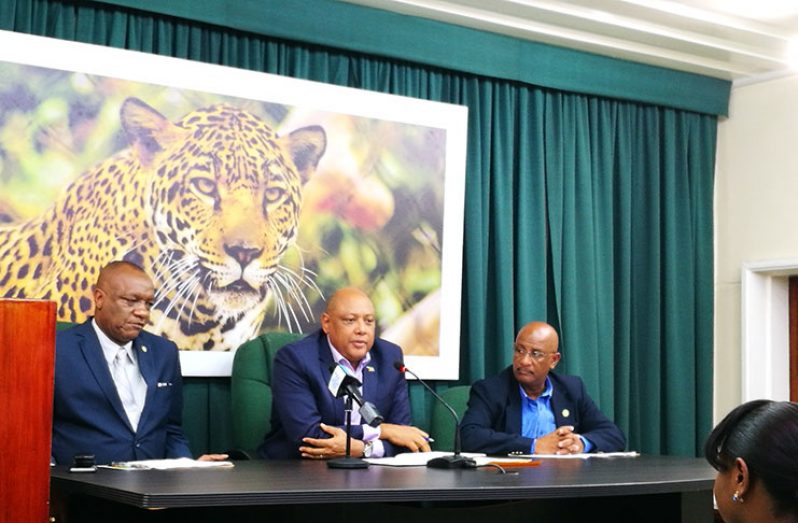 Minister of Natural Resources, Raphael Trotman, (centre) and Minister of State Joseph Harmon (left) address the media on Friday at a post-cabinet press briefing. Also in photo is Communications Director of the Ministry of the Presidency, Mark Archer (right).