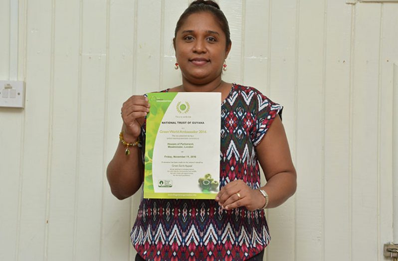 Ms. Nirvana Persaud, Chief Executive Officer of The National Trust of Guyana, displays one of the certificates that her agency won in 2016