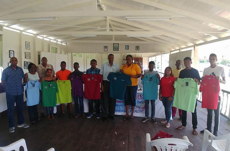 President of the Guyana Diabetic Association, Glynis Alonzo-Beaton, hands over one of the official jerseys to GCA’s Roger Harper, while club representatives, GCA officials, Ansa McAl’s Kalawattie Datt-Singh and DCC coach Garvin Nedd share the moment.
