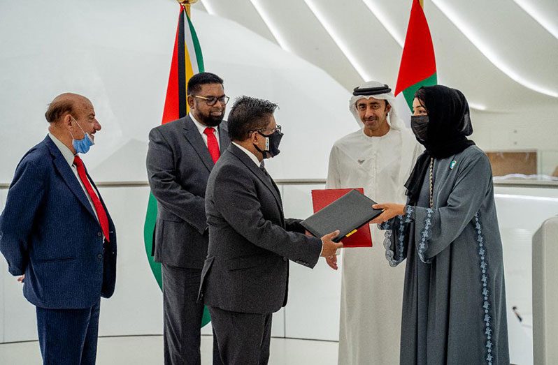 President Dr. Irfaan Ali looks on as Senior Minister of Finance, Dr. Ashni Singh exchanges the MoU with UAE Minister of International Cooperation, Her Excellency Reem Ebrahim Al-Hashimy (Office of the President photo)