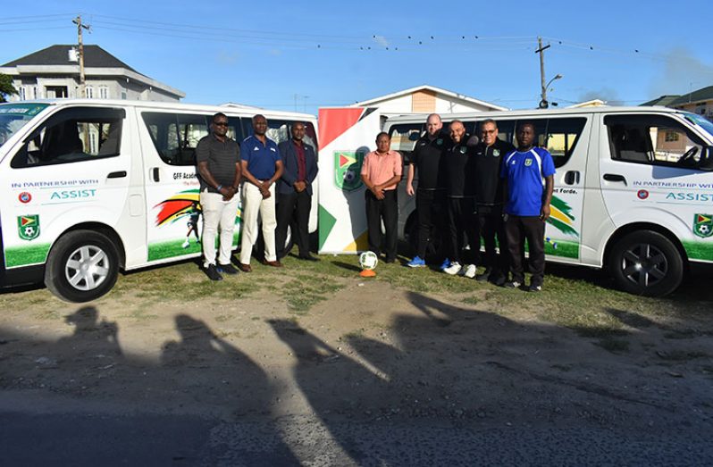 GFF president Wayne Forde joins members of the Federation’s executive committee and technical staff for a photo opportunity following the commissioning of the two minibuses from UEFA.