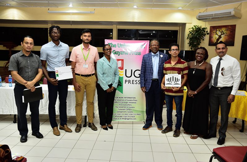 UG Vice-Chancellor, Professor Ivelaw Griffith (centre right) and Manager of UG Press, Danniebelle Mohabir (centre left), pose with winners and sponsors of the logo competition
