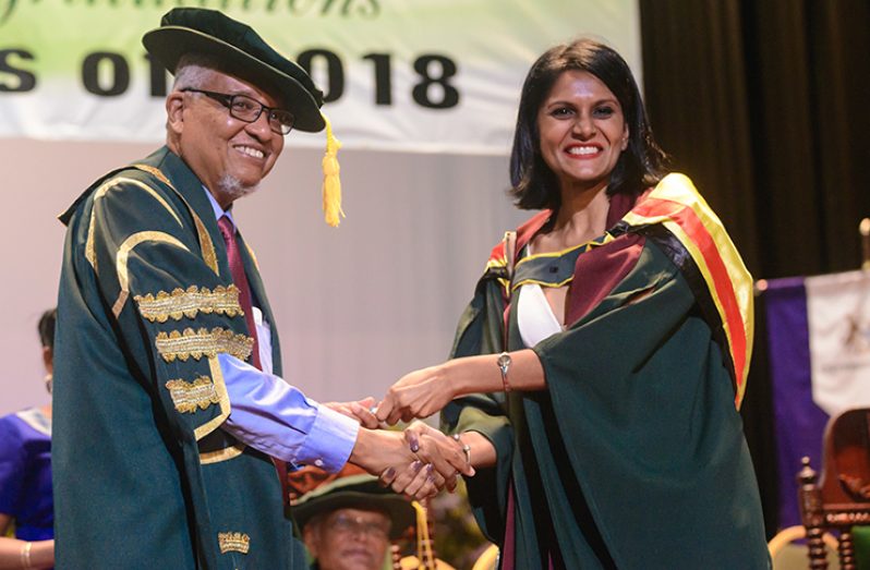 Chancellor of the University of Guyana Professor Eon Nigel Harris presenting Valedictorian Shakti Persaud with a replica of her degree (Delano Williams photo)