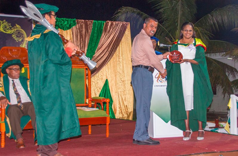 Harry Ghaness, manager of Republic Bank (Rose Hall) presents an award to valedictorian Lori Lee Farley. (Adrian Persaud/Department of Public Information)