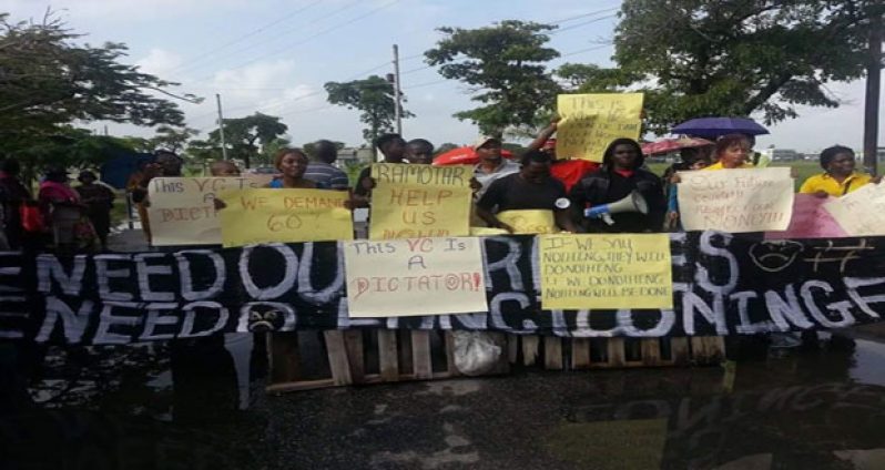 Students manning the barred entrance of the University of Guyana, Turkeyen Campus yesterday