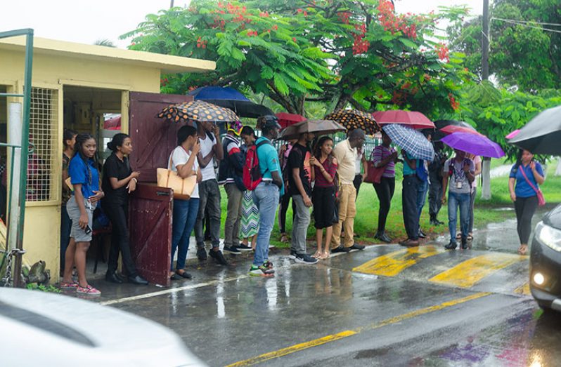 Some students lingered around at UG gate with hopes that they would be allowed into campus after the police completed their search (Delano Williams photo)