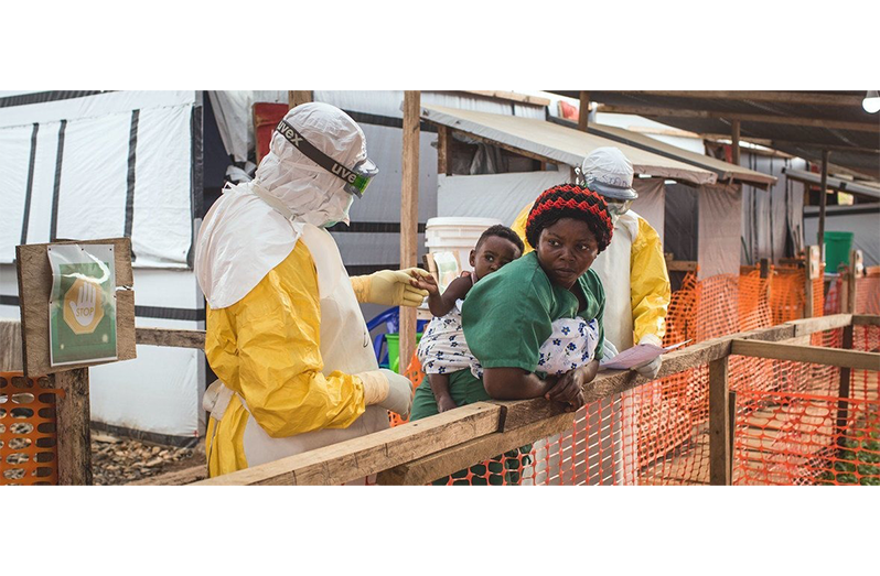 A health worker checks a child for Ebola during an earlier outbreak in DR Congo (UNICEF/Vincent Tremeau)