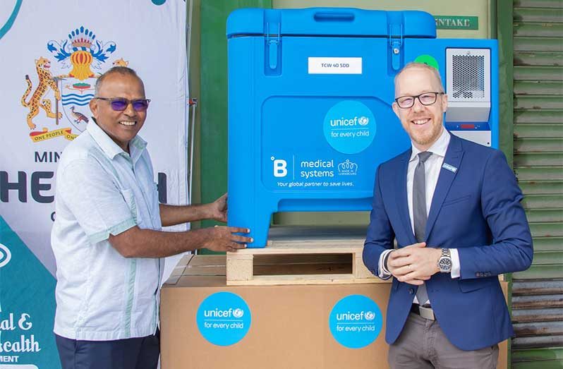 Health Minister, Dr. Frank Anthony, receives refrigerators from Gabriel Vockel, UNICEF Representative