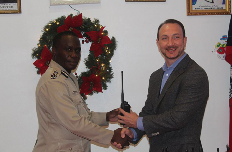 Commissioner of Police Leslie James formally receives the radio sets from Regional Security Officer Josiah Keener