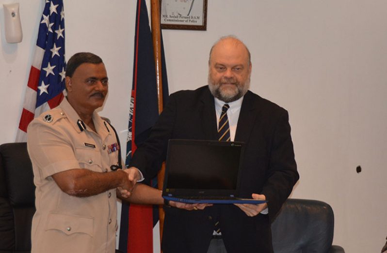 Acting Commissioner of Police David Ramnarine, receiving one of the many donated items from US Ambassador to Guyana, Perry Holloway, at Monday’s handing-over ceremony