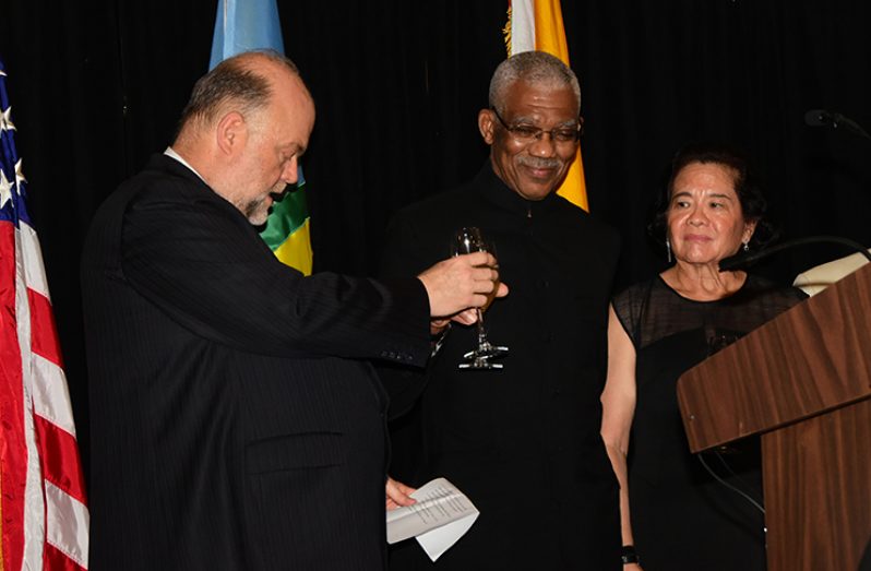 Ambassador Perry Holloway and President David Granger toasting in the presence of  First Lady Sandra Granger