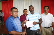 Agriculture Minister Zulfikar Mustapha hands over a cheque for $100,000 to a sugar worker from Uitvlugt Estate 