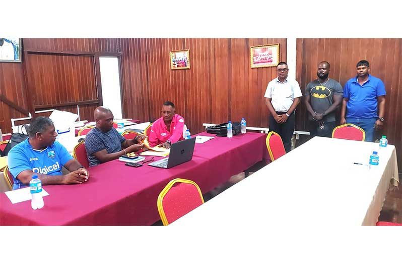 Umpire Dharam Singh, Tejram Baldeo, and Heathcliff Peters (Standing)