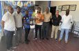 Two members of MSC and DCC pose with the Unity Cup in the presence of, from left, Dr. Linden Dodson, Shaquille Williams (MSC), Roger Harper, Sean Devers and Colwyn Cort
