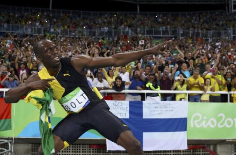 Usain Bolt (JAM) of Jamaica celebrates winning the Jamaican team's gold medal. (REUTERS/Kai Pfaffenbach)