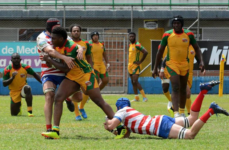 Guyana’s Vallon Adams is being tackled by two Paraguayans during his side’s 86-7 defeat at the Americas Rugby Challenge.