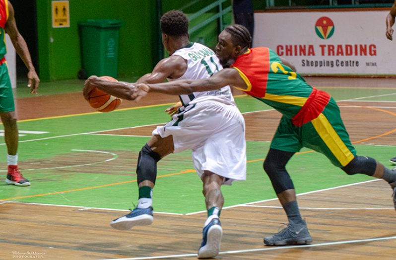 Guyana’s Ray Victor beats his Grenadian defender on his way to scoring during his side’s 97 – 75 points win at the Cliff Anderson Sports Hall. (Delano Williams Photos)