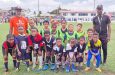Wheatland Fordyce, Coach and Referee (left) and Assistant Coach Dexter Duncan with some of the kids at the fun-day on Saturday (Telesha Ramnarine photo)