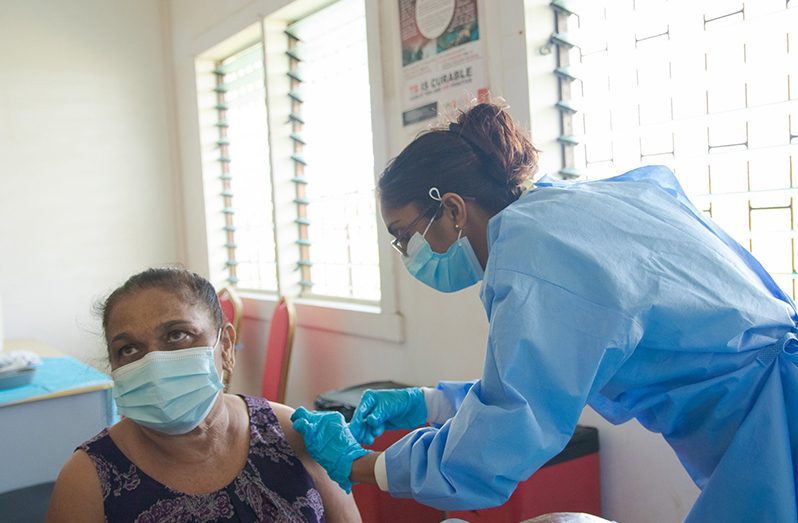 A woman receives her first dose of vaccine