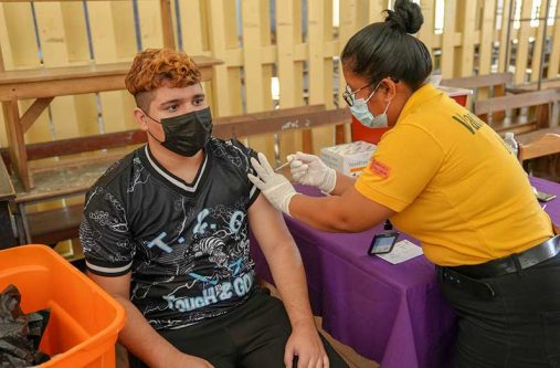 An adolescent receives his first dose of the Pfizer vaccine