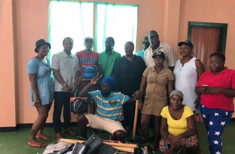 Residents pose with Minister Simona Broomes when they recently received tools for use in community employment projects.