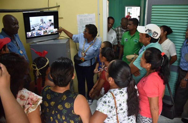 Minister of Public Telecommunications, Catherine Hughes explains to residents of Orealla, in Region Six, how the video-conferencing equipment works.