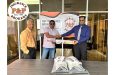 Vikash Panday (right) hands over part of the gear to Anil Beharry. Bish Panday is at extreme left
