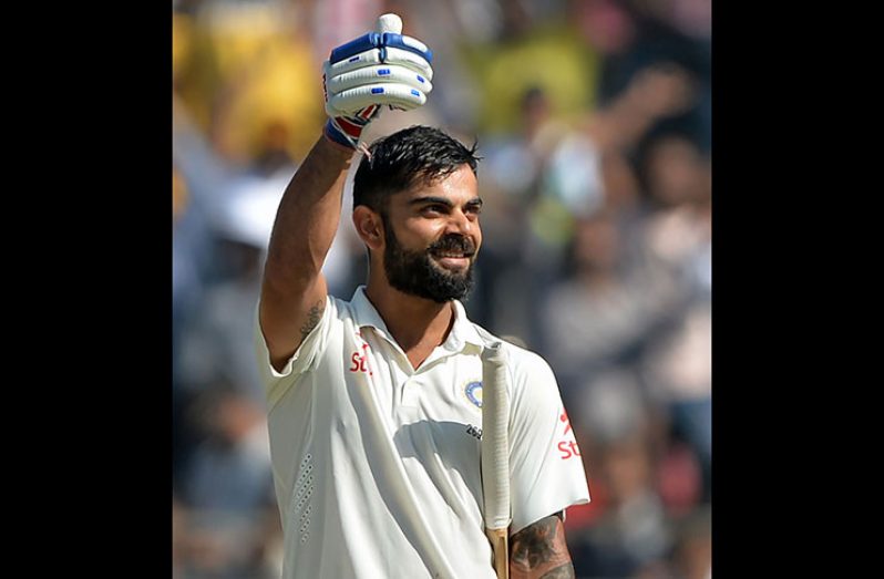 Thumbs up: Virat Kohli was all smiles on reaching his double century on the fourth day in Mumbai