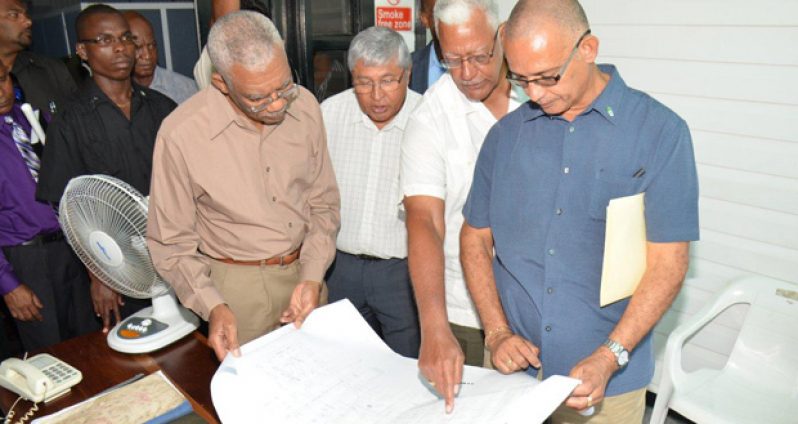 President Granger looks at a plan of the GuySuCo facility with (from right) Director of Protocol at the Ministry of the Presidency, Col. Francis A. Abraham; Minister of Agriculture, Mr. Noel Holder; and Chief Executive Officer of GuySuCo, Mr. Errol Hanoman