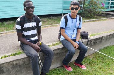 Ceion and his friend Asif Khan sit outside the Centre for Communication Studies at the Turkeyen Campus recently. Khan is also pursuing studies in the social sciences field at UG.