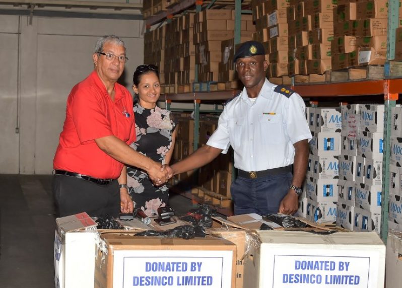 DeSinco Limited Trading's CEO, Mr. Frank DeAbreu  and Sales and Marketing Director Ms. Alicia DeAbreu hand over 50 hampers of food items to Lieutenant Colonel Kester Craig, CDC's Director General. (MOTP photo)