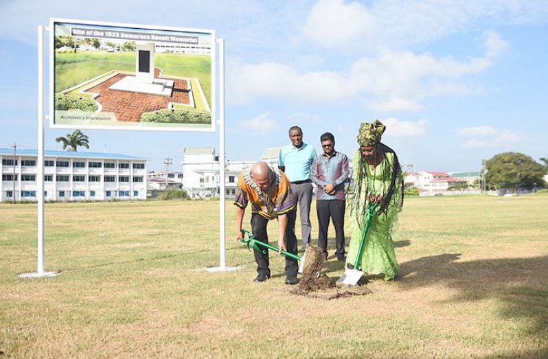 Minister of Social Cohesion, Dr. George Norton (left) and President of the Ghana Day Organisation, Sister Penda Guyan turn the sod at Parade Ground in September 2019 where the new memorial will be placed. In the background are Deputy Mayor Alfred Mentore (left) and Mayor of Georgetown, Ubraj Narine (Samuel Maughn photo)