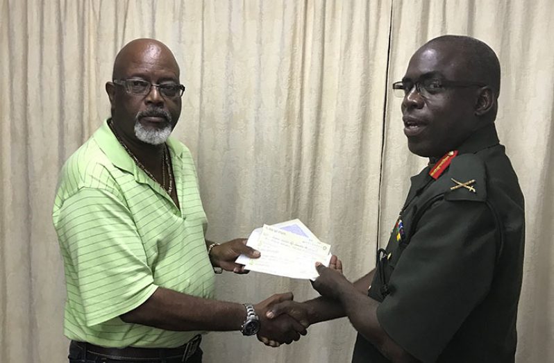 Secure Innovations and Concepts CEO Harold Hopkinson (right) hands over his donation to the Guyana NRA president Brigadier Patrick West.