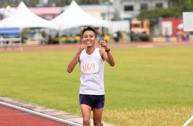 Rekie Williams celebrating as he crossed the finish line to win the Boys Open 10K Road Race