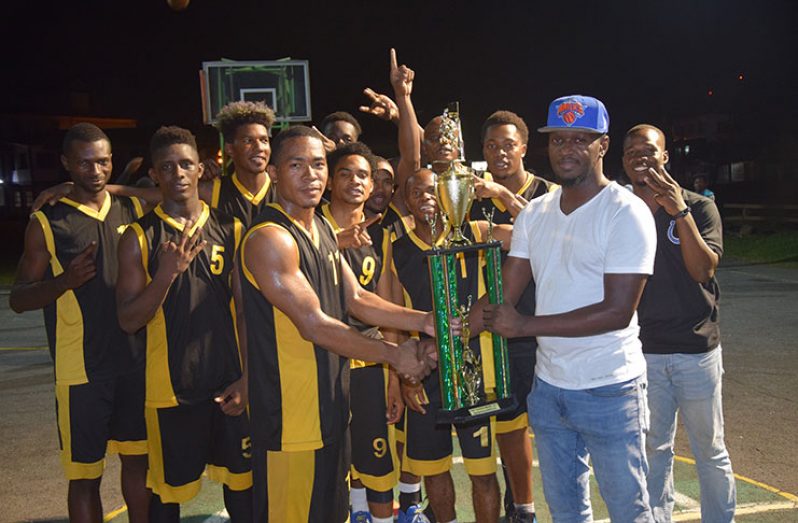Colts captain Shelroy Thomas collects the winning trophy from GABA’s Rawle Toney after his team’s 93-86 points win over Plaisance Guardians.
