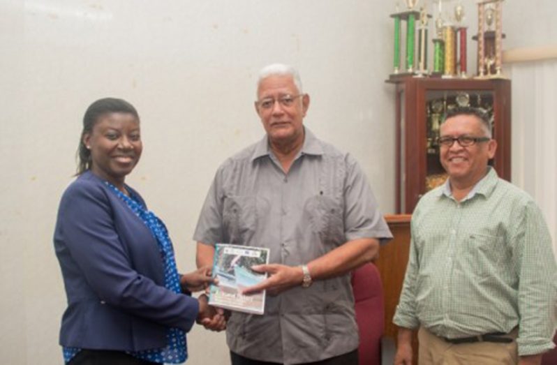 Country Manager of WWF Guianas, Aiesha Williams hands over the Artisanal Fishery Management Plan to Minister of Agriculture, Hon. Noel Holder and Chief Fisheries Officer within the Department of Fisheries, Denzil Roberts
