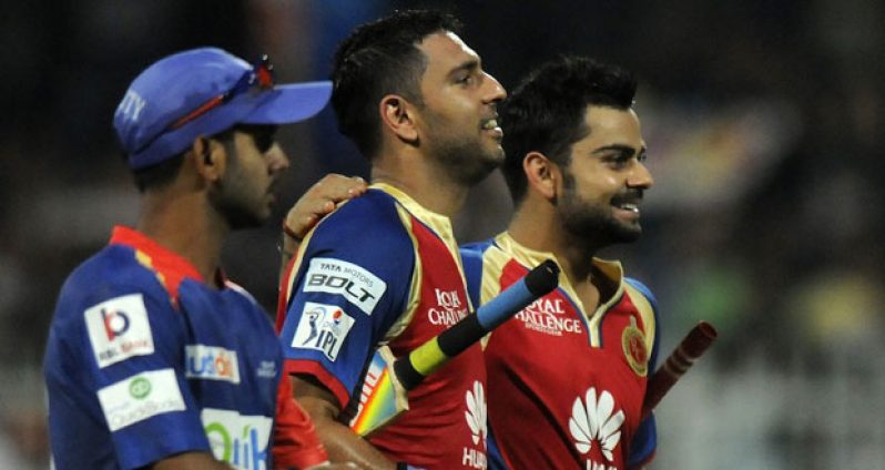 Royal Challengers Bangalore’s Virat Kohli and Yuvraj Singh walk off victorious, following their team’s eight-wicket victory over Delhi Daredevils yesterday.