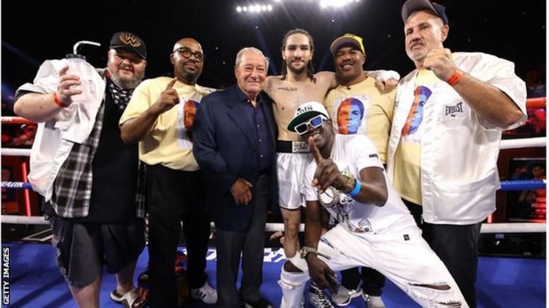 Ali Walsh celebrated the win in the ring with his team including promoter Bob Arum (blue suit) and his godfather rapper Flava Flav (front)