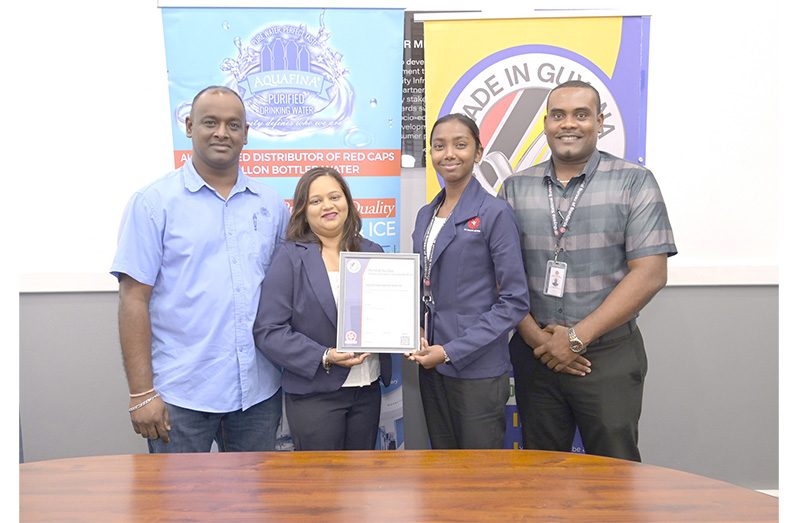 Aquafina Director Nalini Latchana receives the Made in Guyana Certificate from GNBS Technical Officer, Rachel Cecil