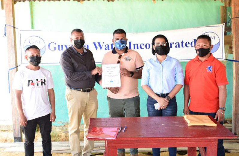 Minister of Housing and Water, Collin Croal hands over a contract during Saturday’s signing ceremony. Also, in photo Minister within the Ministry of Housing and Water, Susan Rodrigues (DPI photo)